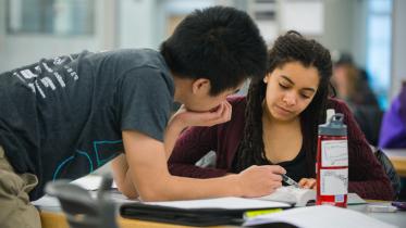 Two students studying at a table.