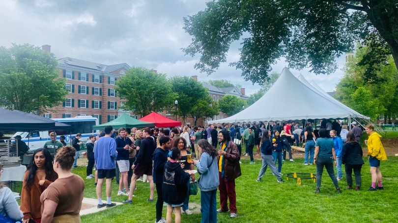 Numerous students on Gold Coast lawn playing lawn games, drinking beverages, and gathering
