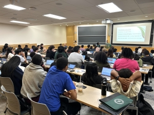 A classroom of first-year students participating in the FYSEP pre-orientation program, seated at desks with laptops open, attentively facing two presenters at the front of the room.
