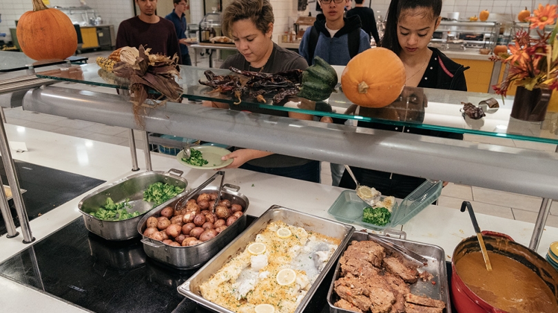 Students get food in the dining hall.