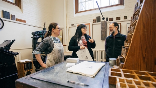 Sarah Smith, director of the Book Arts Workshop, and workshop participants Candessa Tehee and Ed Rayher demonstrate printing with Cherokee type in the Book Arts Workshop.