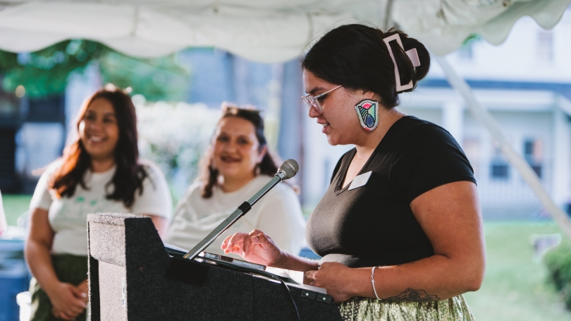 Leora DePerry '26 at podium giving announcements at the Welcome Dinner