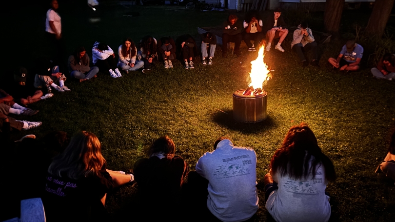 Indigenous Peer Mentors and incoming students around a fire