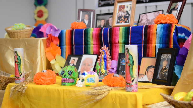 A table displays pictures and icons to celebrate the Day of the Dead.