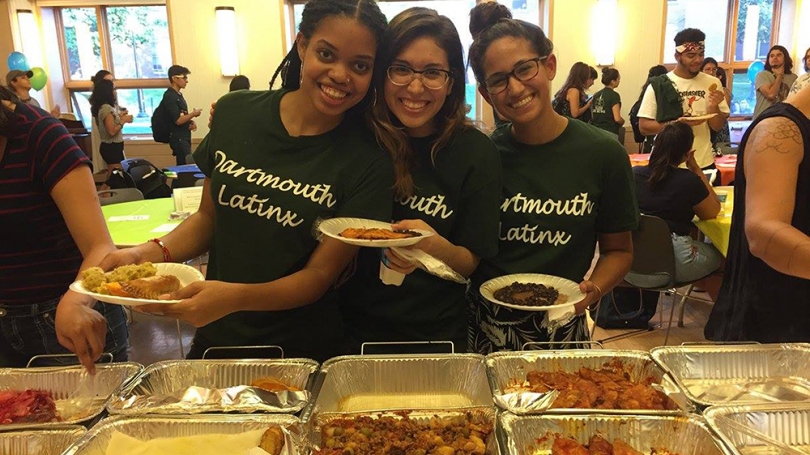 Three students pose during a Latinx dinner event.