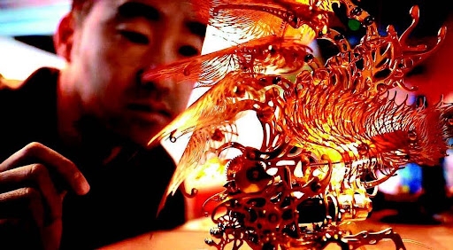 photo of individual looking at a piece of fine art (orange, yellow, red coloring)