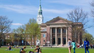 Students studying and talking on the green in front of the library.
