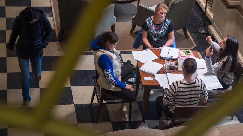 A group of students studying in the Baker library front hall.