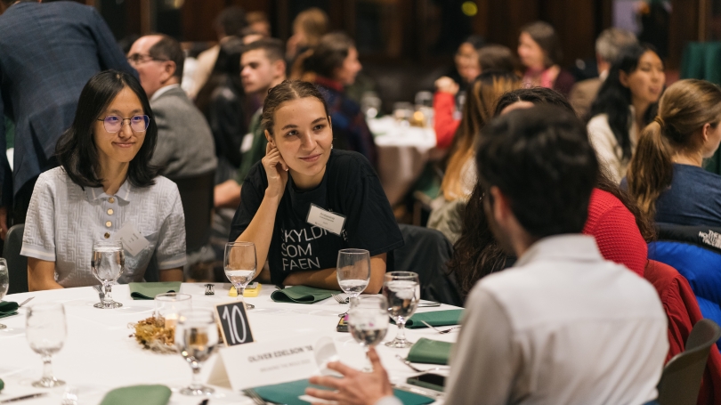 A group of people sitting around a table talking.