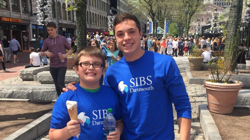 Student and mentee outside Fanueil Hall and Quincy Market in Boston eating ice cream