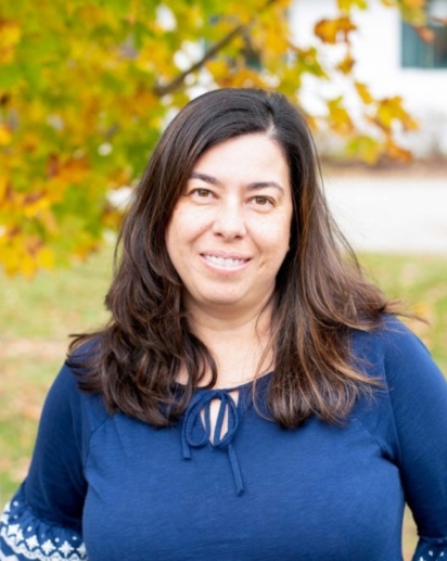 woman with long dark hair, fair skin, and a blue shirt