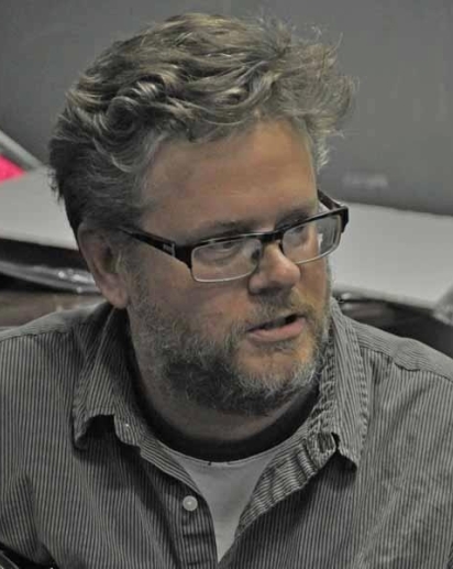 Man with salt and pepper beard wearing glasses and a gray shirt