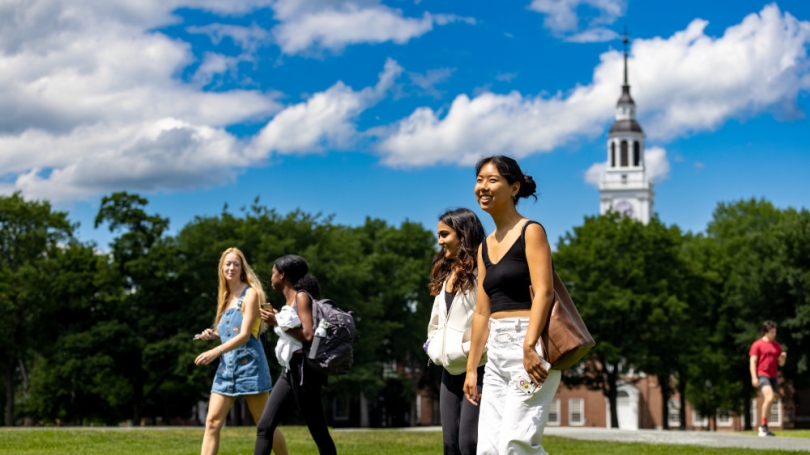 Students walking on the Dartmouth Green with the Baker clock tower in the background