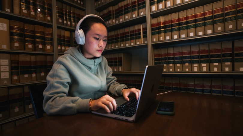 Student studying with headphones in library