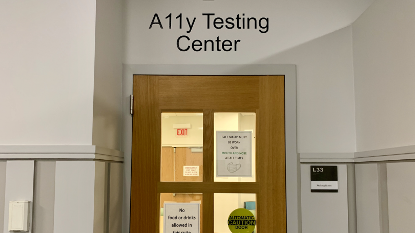 photo of the A11y Testing Center front door. A wooden door with 4 glass panes, and a sign to the right reading "L33, Waiting Room"