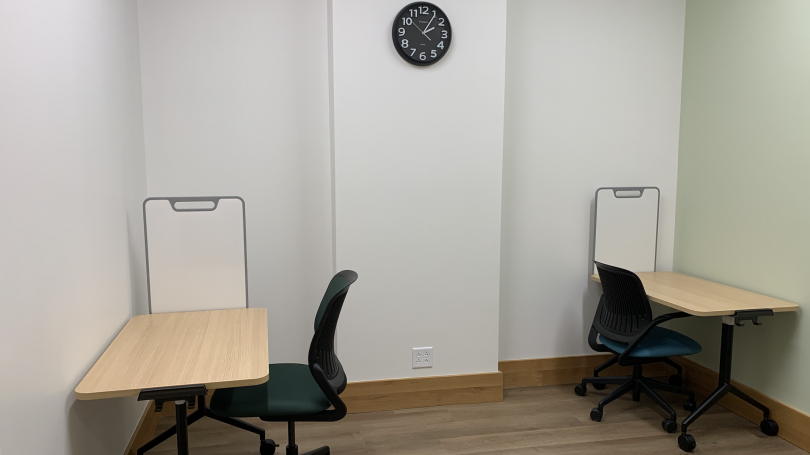 image of two testing desks with movable white boards each facing opposing walls