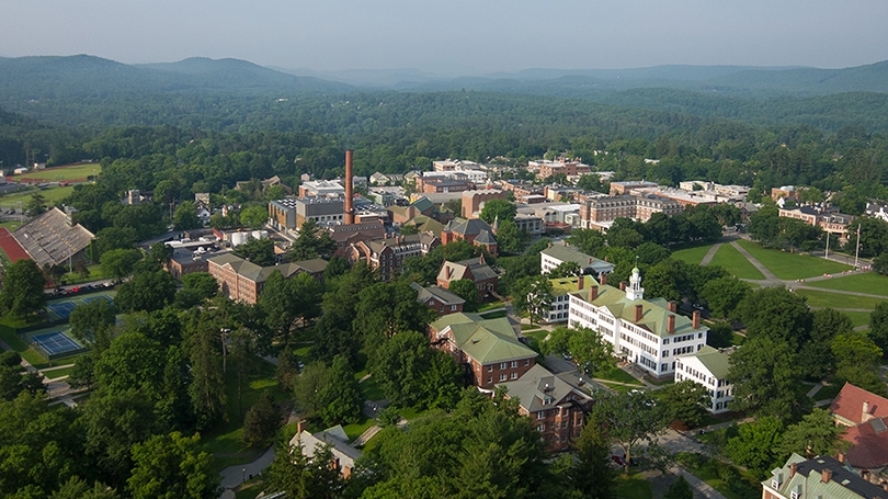 an aerial view of campus, with green trees and mountains in the background