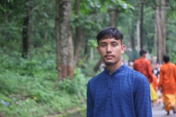photo of Laxman Bist in blue shirt in front of greenery and trees