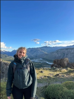 Reece smiling at camera with landscape in background