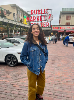 person smiling at camera in front of Seattle Public Market